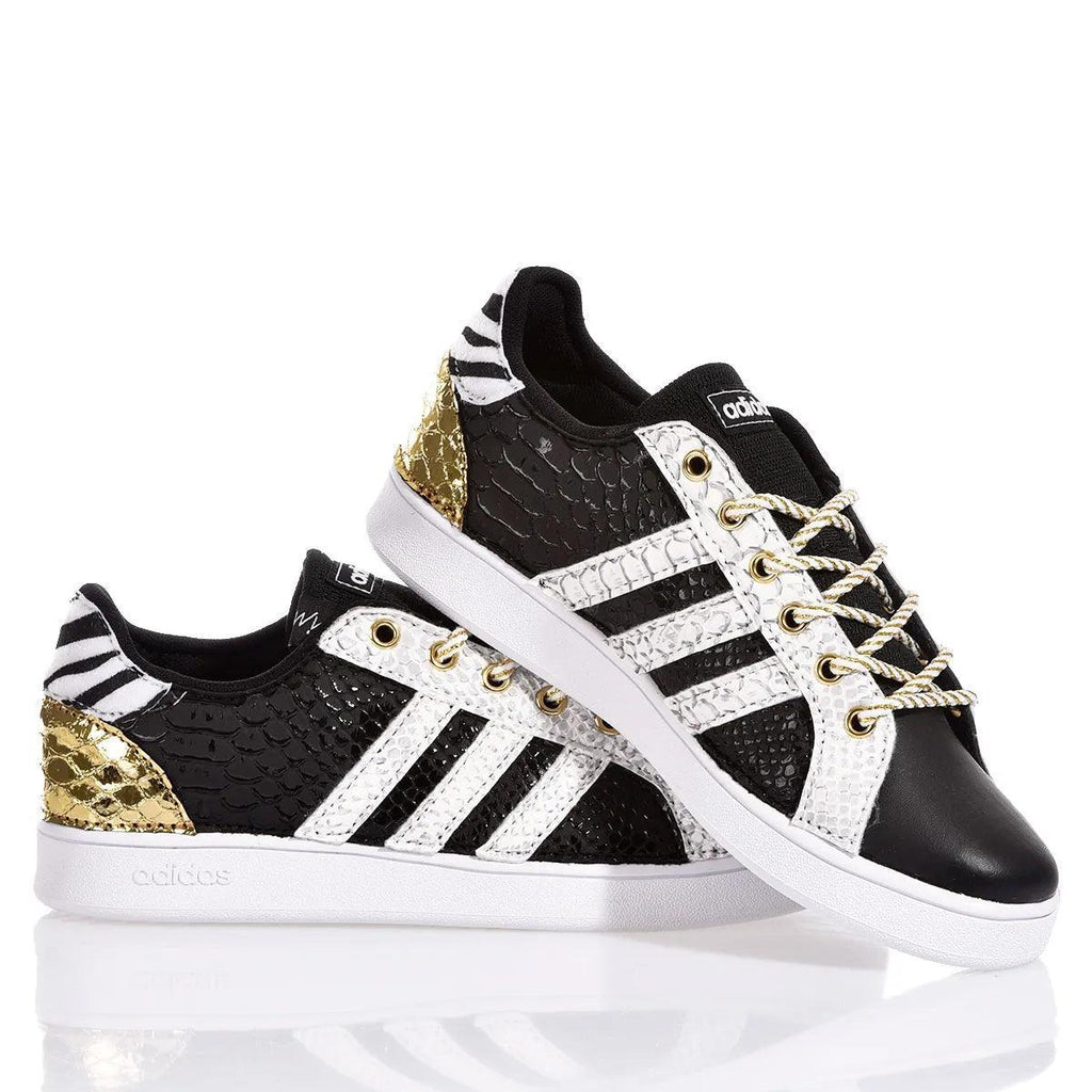 Sneakers Adidas customizzate nere con dettagli oro e bianco, suola bianca, lacci intrecciati